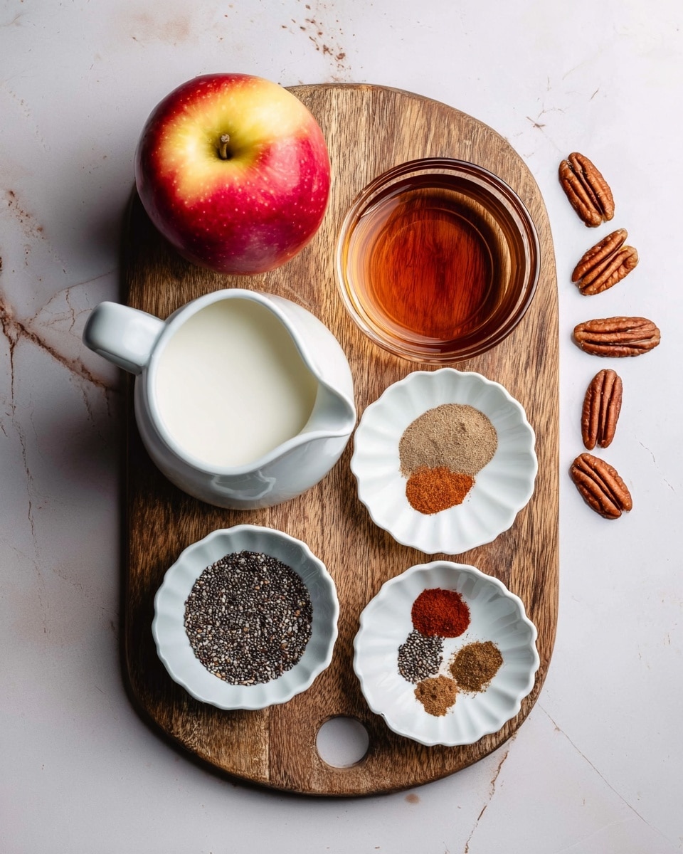 A wooden board on a white marbled surface holds several ingredients arranged neatly. There is a red and yellow apple on the left side, with a white pitcher filled with milk below it. At the top center of the board is a clear glass bowl containing a dark amber liquid. Next to it on the right is a white scallop-edged bowl with five small piles of spices in different browns and tans. Below that is a white bowl full of small round black and white chia seeds. Scattered around the board are several pecan nuts. photo taken with an iphone --ar 4:5 --v 7