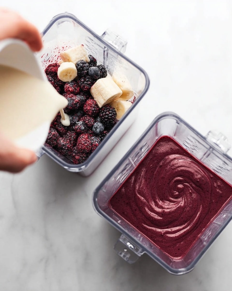 The image shows two square clear blender containers placed on a white marbled surface. The left container holds three visible layers: the bottom layer is dark purple and black frozen berries, the middle layer consists of small white banana pieces, and a woman's hand is pouring white liquid over the top. The right container shows a smooth blend of dark purplish-red thick smoothie with a gentle swirl pattern on top. photo taken with an iphone --ar 4:5 --v 7