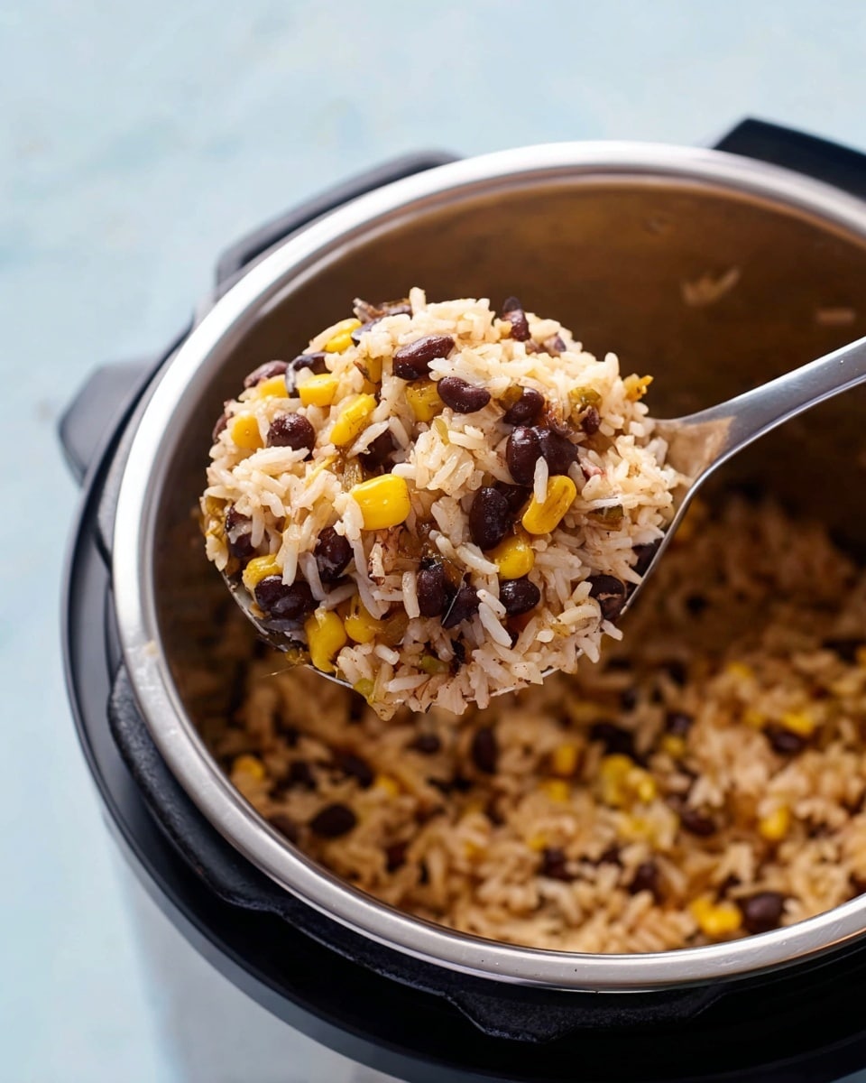 A close-up of a silver spoon holding a mix of cooked rice, black beans, and yellow corn, showing a three-layer texture with white rice grains, dark black beans, and small yellow corn kernels evenly mixed. The spoon is above a black and silver cooking pot filled with the same rice mixture, resting on a white marbled surface. The background is light blue, creating a bright and clean setting. photo taken with an iphone --ar 4:5 --v 7
