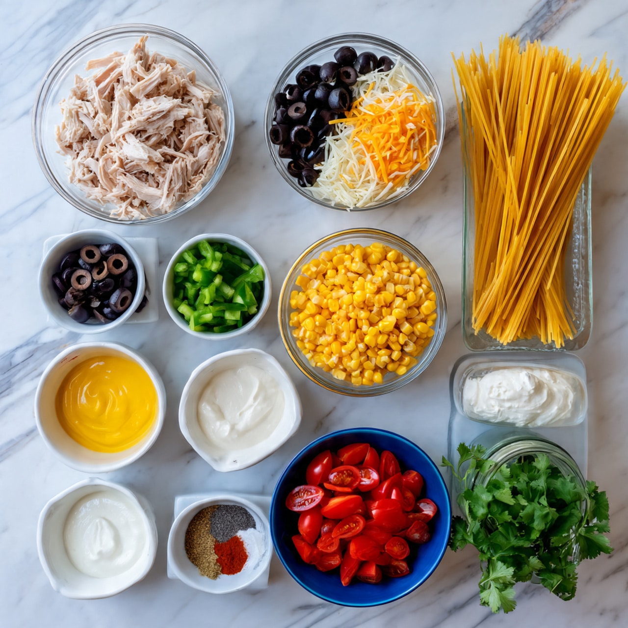 The image shows a white rectangular baking dish filled with a layered pasta bake. The top layer is golden yellow cheddar cheese melted unevenly, with melted white cheese patches mixed throughout. Scattered black olive slices and bits of green herbs are spread over the surface. Below the cheese, you can see spiraled noodles mixed with small pieces of tomato and sweet corn, adding yellow and red colors. The dish rests on a light-colored cloth with thin blue stripes, a wooden spatula on the side, and the background is a white marbled surface. Photo taken with an iphone --ar 4:5 --v 7