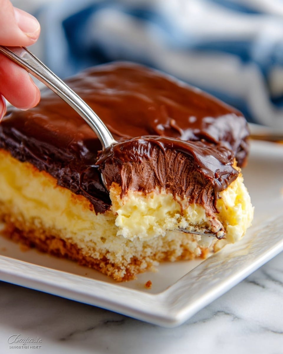 The image shows a close-up of a white square plate holding a piece of cake with three visible layers. The bottom layer is a light brown, crumbly cake base. Above this is a thick, creamy yellow layer that looks smooth and soft. The top layer is dark brown chocolate icing, glossy and rich, covering the cake evenly. A silver spoon is scooping a piece of the cake, showing the textures clearly, and a woman's hand is holding the spoon. The background is a white marbled surface with a blurred blue and white striped cloth behind the plate. Photo taken with an iphone --ar 4:5 --v 7