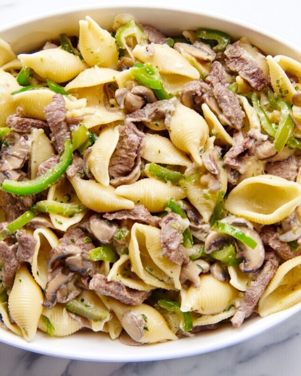 A close-up view of a white dish filled with pasta shells layered throughout; the shells are pale yellow and have a smooth texture. Mixed evenly among the pasta are thin slices of cooked beef, which have a light brown color. Scattered also are strips of green bell pepper and mushrooms, adding a mix of bright green and soft beige colors to the dish. The dish sits on a white marbled surface, creating a clean and bright background. photo taken with an iphone --ar 4:5 --v 7