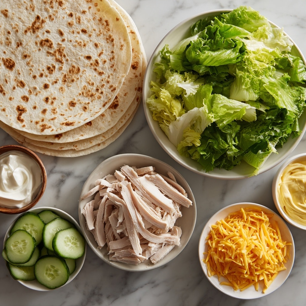 A woman's hand holds a small, sliced wrap showing four layers: a light brown soft tortilla outer layer, a creamy pale yellow cheese layer inside, a middle layer of thinly sliced pale turkey meat, and fresh green lettuce with a drizzle of light beige creamy sauce. In the background, several similar wrap slices are placed closely together on a wooden board. The setting is on a white marbled surface. photo taken with an iphone --ar 4:5 --v 7
