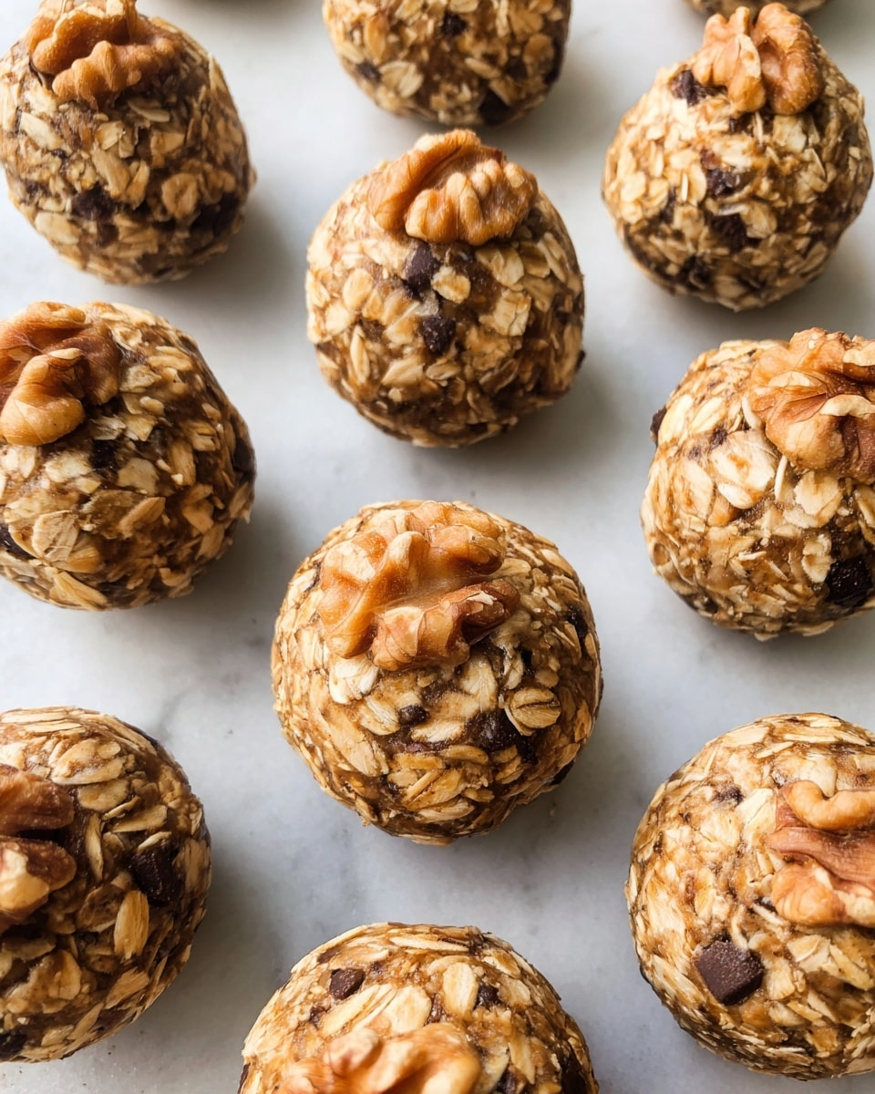 The image shows several round energy balls placed in rows on a white marbled surface. Each ball has a rough texture made of visible light brown rolled oats mixed with small darker spots from chocolate chips or nuts. Some of the balls have whole walnut pieces on top, adding a rough, curved shape and a deeper brown color contrast. The oats appear slightly sticky and packed tightly, holding the balls together with a natural, homemade look. The photo has soft lighting that highlights the texture and natural colors of the oats and nuts. photo taken with an iphone --ar 4:5 --v 7