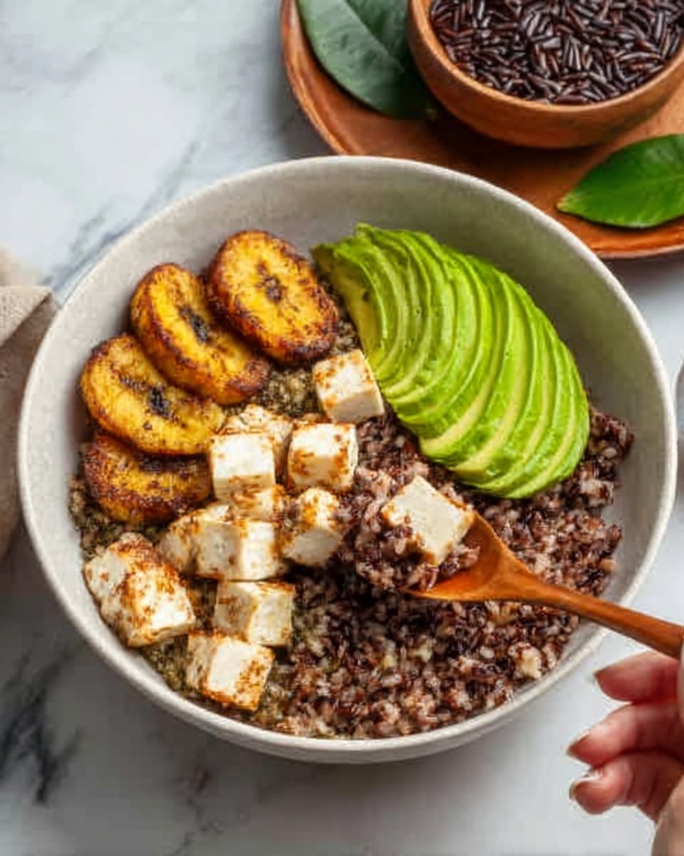 A white bowl sits on a white marbled surface, filled with several layers of food. At the bottom is a dark brown, crumbly grain or rice layer with mixed textures. On top of this is a creamy white layer of cheese or tofu cubes placed near the edge. Next to the cheese cubes are three slices of golden yellow grilled plantains arranged neatly in a row. On the opposite side of the cheese, there is a fan of thinly sliced, bright green avocado with a smooth texture. A woman's hand holding a wooden spoon is scooping from the bowl. In the background, a brown bowl with additional dark grains and a wooden plate with green leaves are visible. Photo taken with an iphone --ar 4:5 --v 7