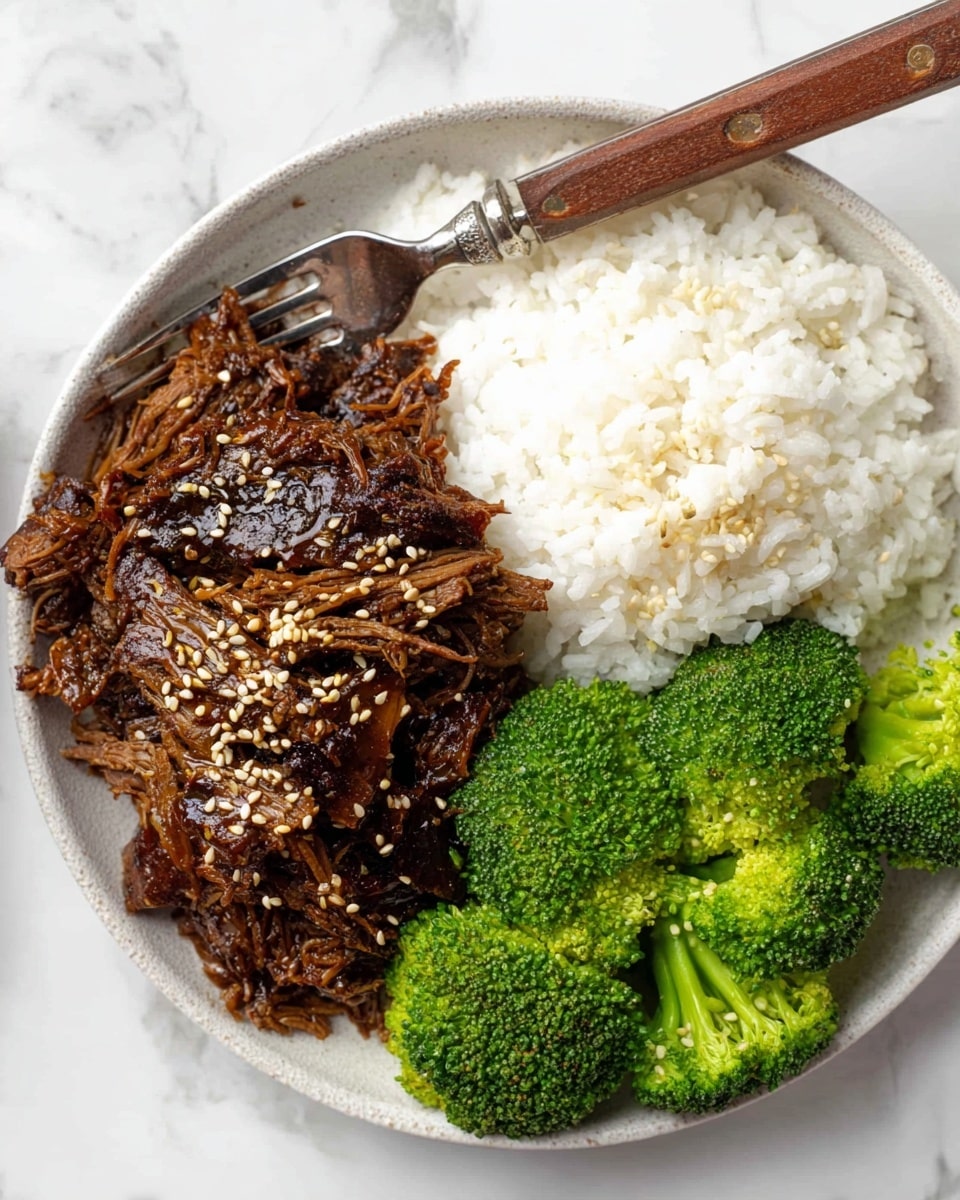 A white round plate with three layers of food: on the left side, there is dark brown shredded meat with a shiny glaze, sprinkled with light tan sesame seeds, and a silver fork with a wooden handle placed on it; on the right side, there is a mound of white rice with soft texture, and at the bottom right, bright green steamed broccoli florets with a slightly bumpy surface. The plate is placed on a white marbled surface. photo taken with an iphone --ar 4:5 --v 7