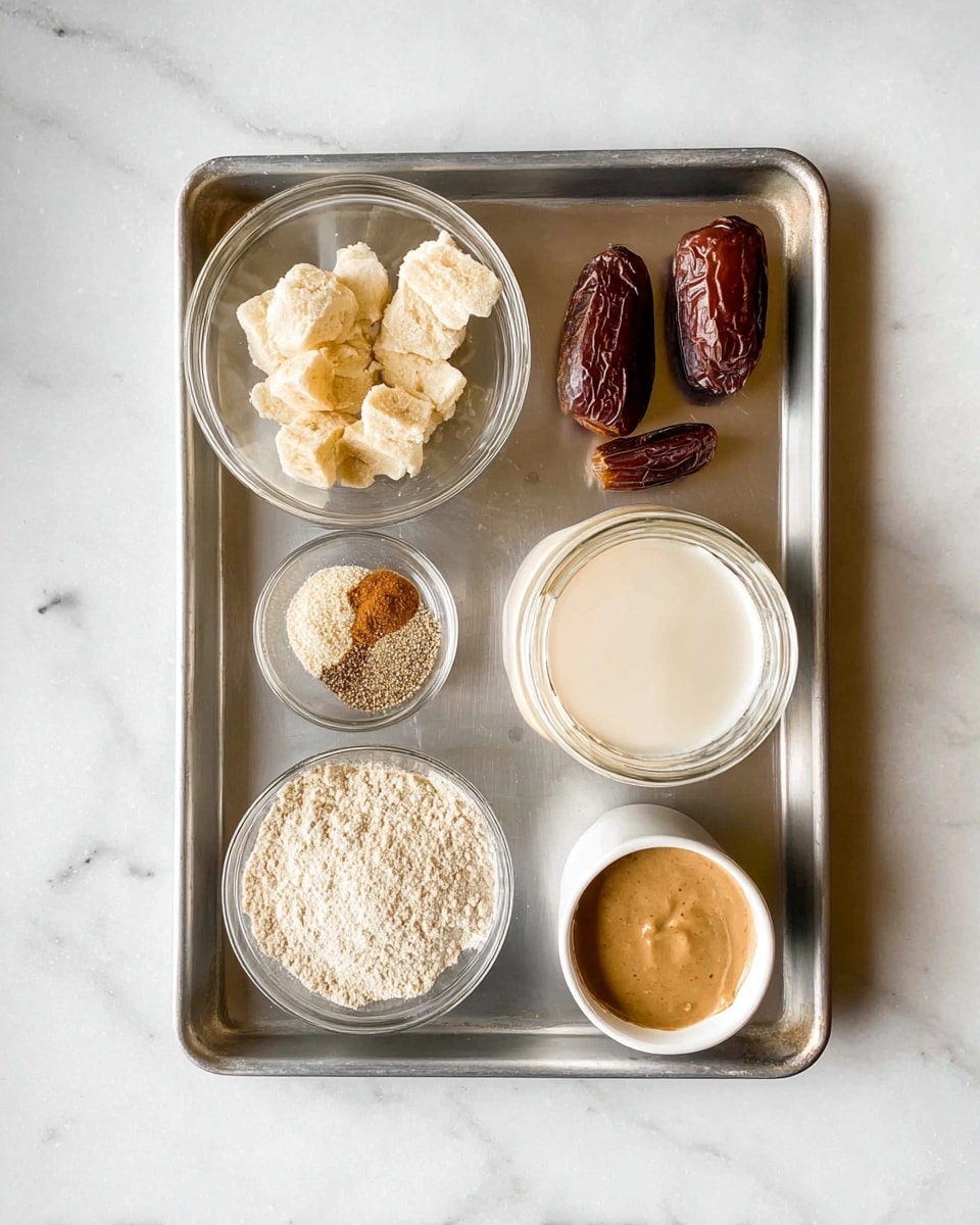 A metal tray holds seven containers of ingredients arranged neatly on a white marbled surface. In the top left is a clear glass bowl with frozen banana pieces, next to it on the right are two whole dates. On the right side of the tray is a glass jar filled with creamy plant milk. Below the bananas is a tiny clear bowl with a mix of ground spices, and just below that is a larger clear bowl with ground flaxseed. In the bottom left corner is a white bowl with a light beige powder, likely flour, and next to it on the right is a small white cup filled with a thick, light brown liquid, possibly nut butter. The setup shows a clean and organized arrangement of vegan baking ingredients photo taken with an iphone --ar 4:5 --v 7