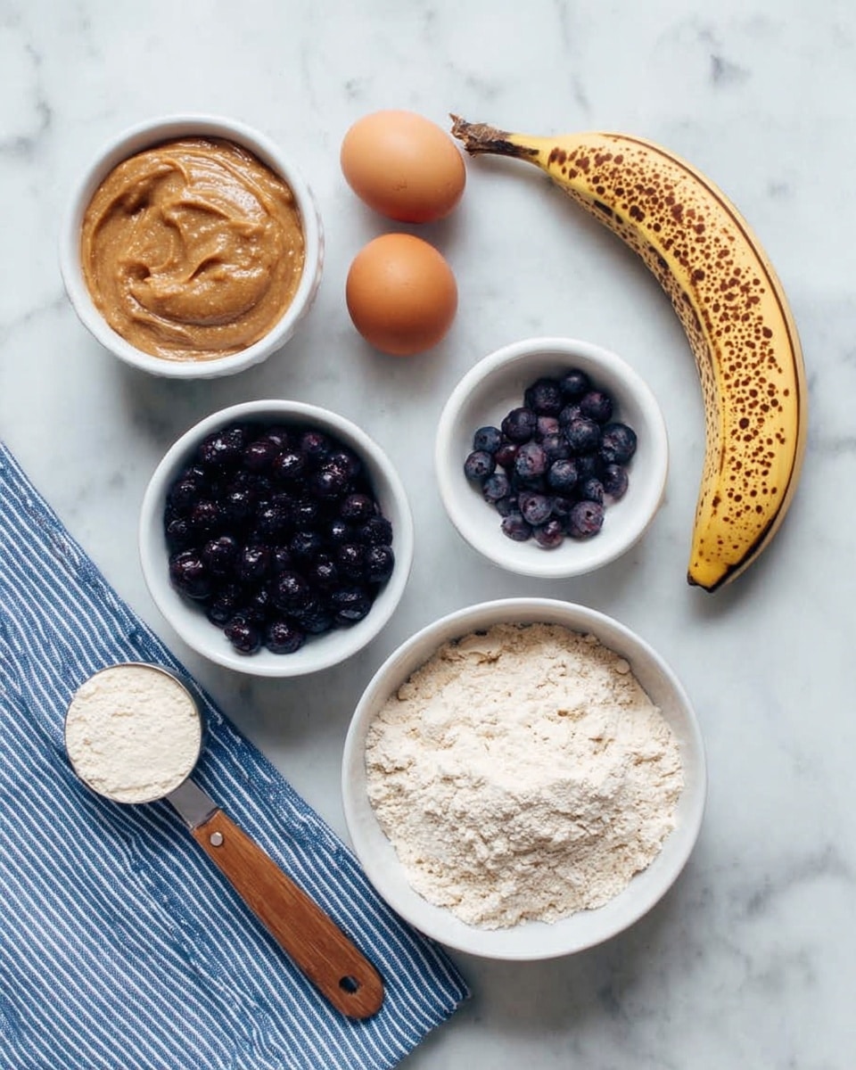 The image shows several baking ingredients neatly arranged on a white marbled surface. There are two brown eggs placed near a ripe brown-spotted banana at the top right. A white bowl filled with light beige flour is at the bottom right. Next to it, a smaller white bowl holds dark blue frozen blueberries. To the left, there is a white bowl filled with light brown almond butter and another empty white bowl nearby. A wooden-handled measuring spoon with white powder rests on the far left. A blue and white striped cloth is partially visible under the bowls. photo taken with an iphone --ar 4:5 --v 7